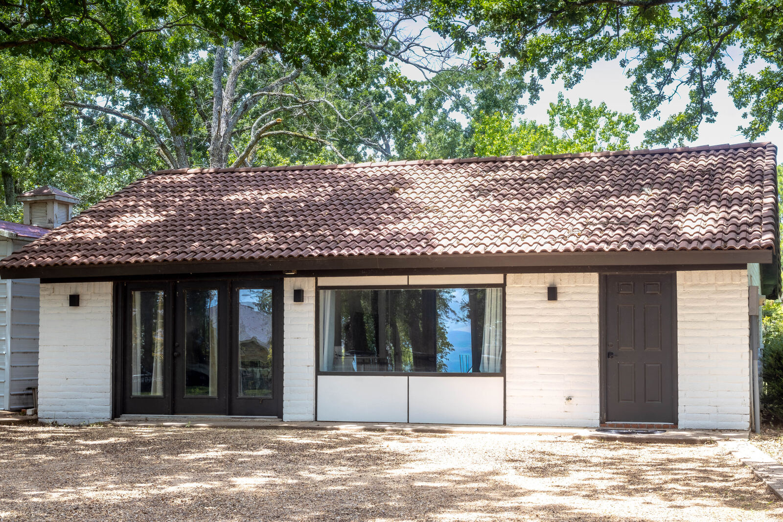 The casita — white brick, tile roof, lake reflected in the picture window