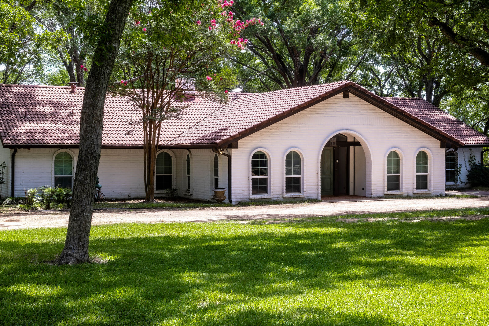 The main house at 6851 Double Bridge Road — arched entry under the crape myrtles