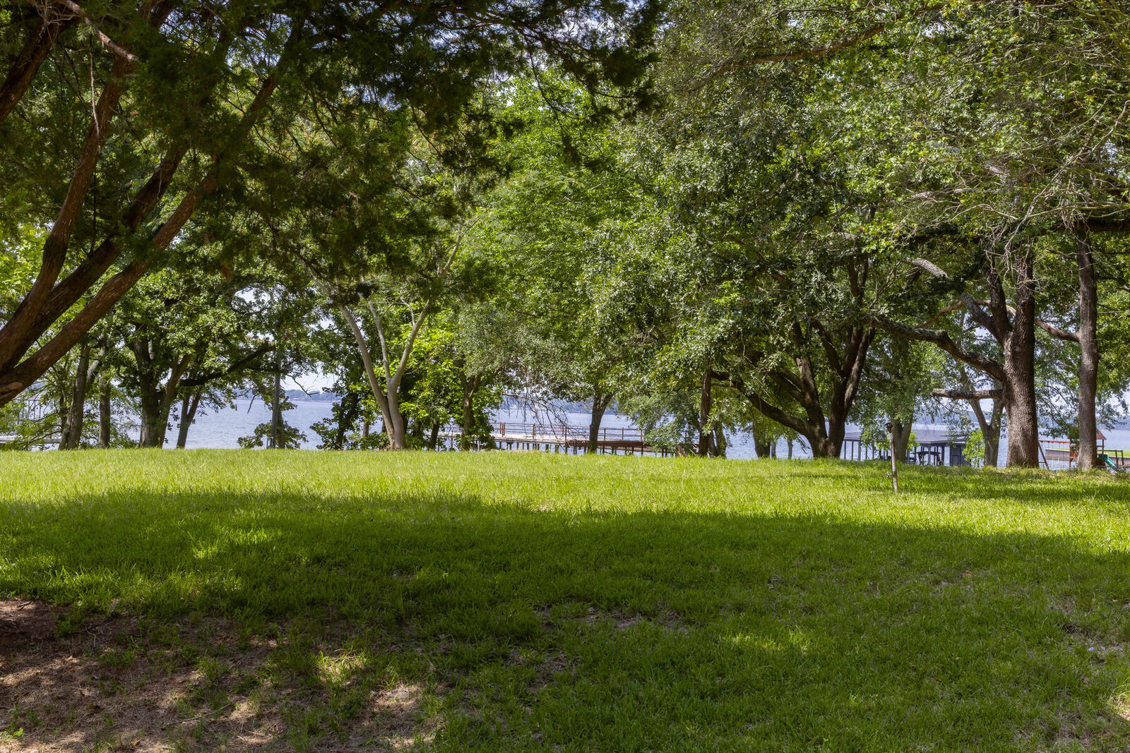 Open lawn under the oaks with the lake beyond