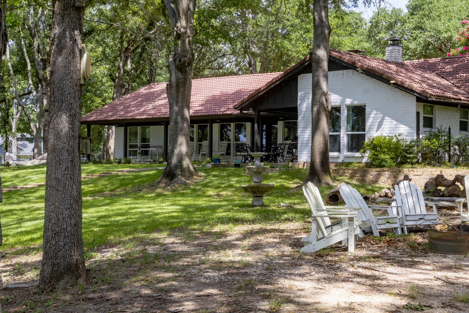 The lake-facing porch behind the Adirondack chairs