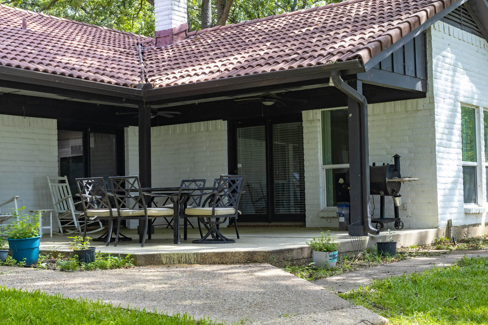 Covered patio with dining table and smoker