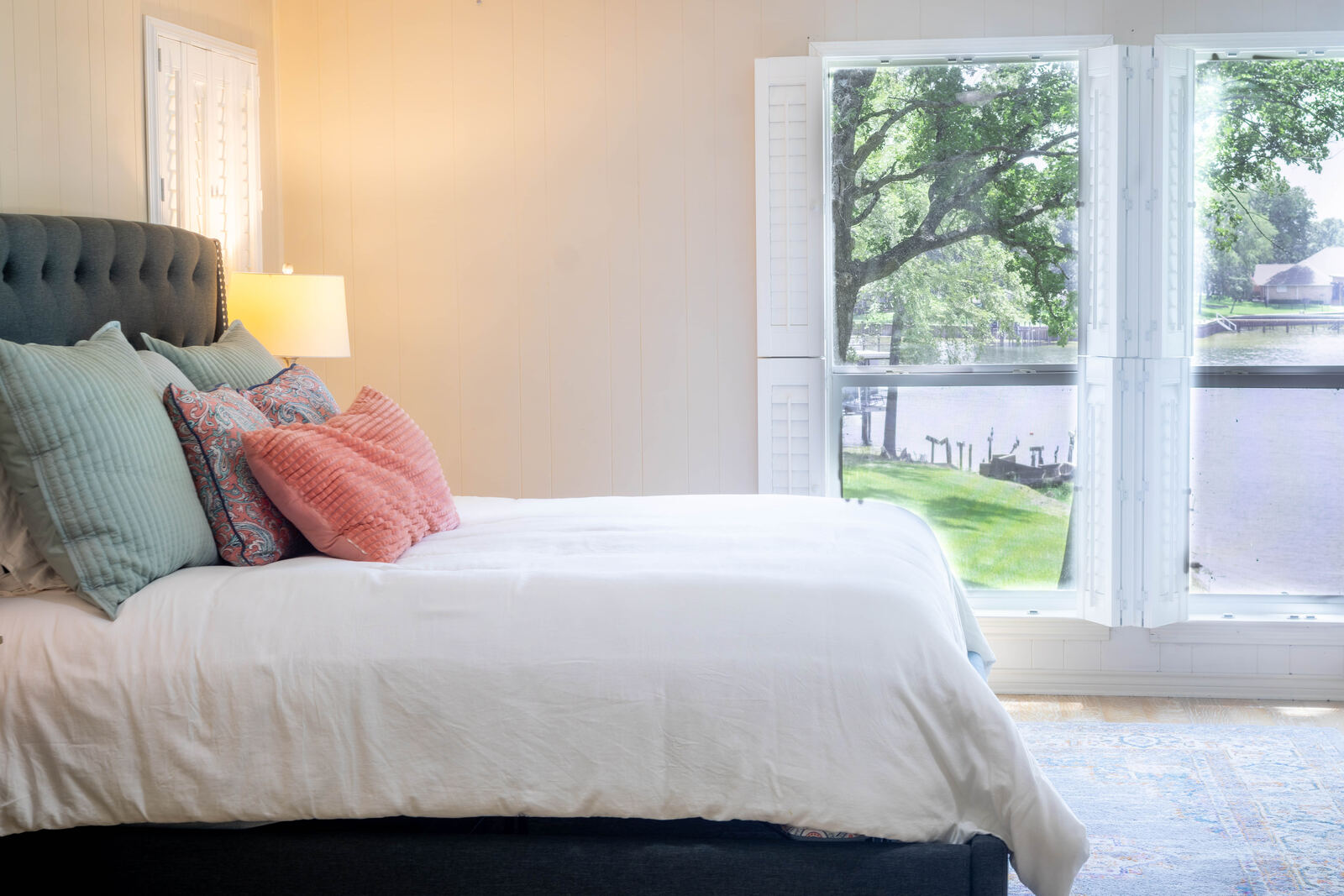 Primary bedroom with the lake through plantation shutters